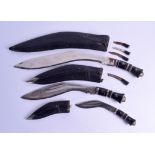 A GROUP OF THREE GRADUATED INDIAN KUKRI TYPE DAGGERS with leather scabbards. Largest 53 cm long. (