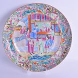 A 19TH CENTURY CHINESE CANTON FAMILLE ROSE PLATE painted with eight people within an interior. 25 cm