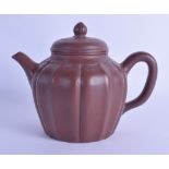 A CHINESE YIXING POTTERY TEAPOT AND COVER of lobed form with fruiting finial. 18 cm wide.