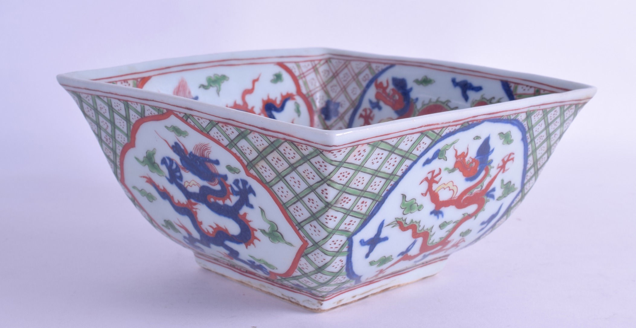 A CHINESE WUCAI SQUARE FORM BOWL bearing Jiajing marks to base, painted with dragons amongst clouds.