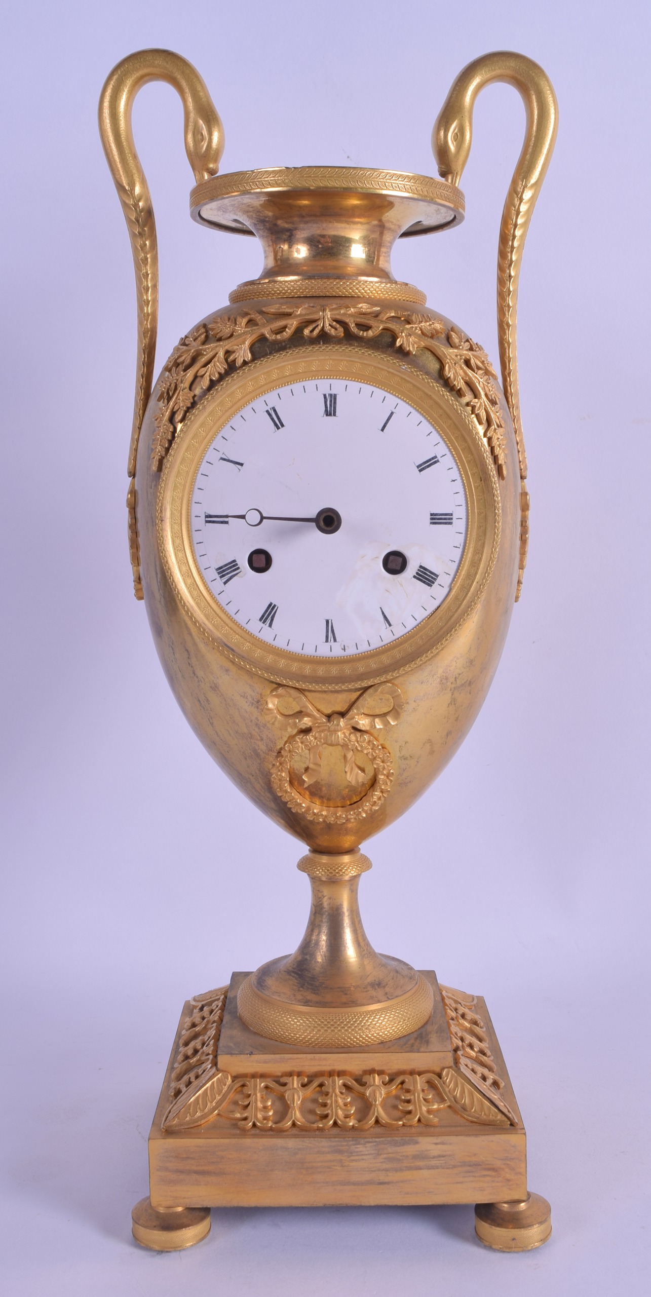 A STYLISH EARLY 19TH CENTURY FRENCH EMPIRE TWIN HANDLED MANTEL CLOCK overlaid with vines, the