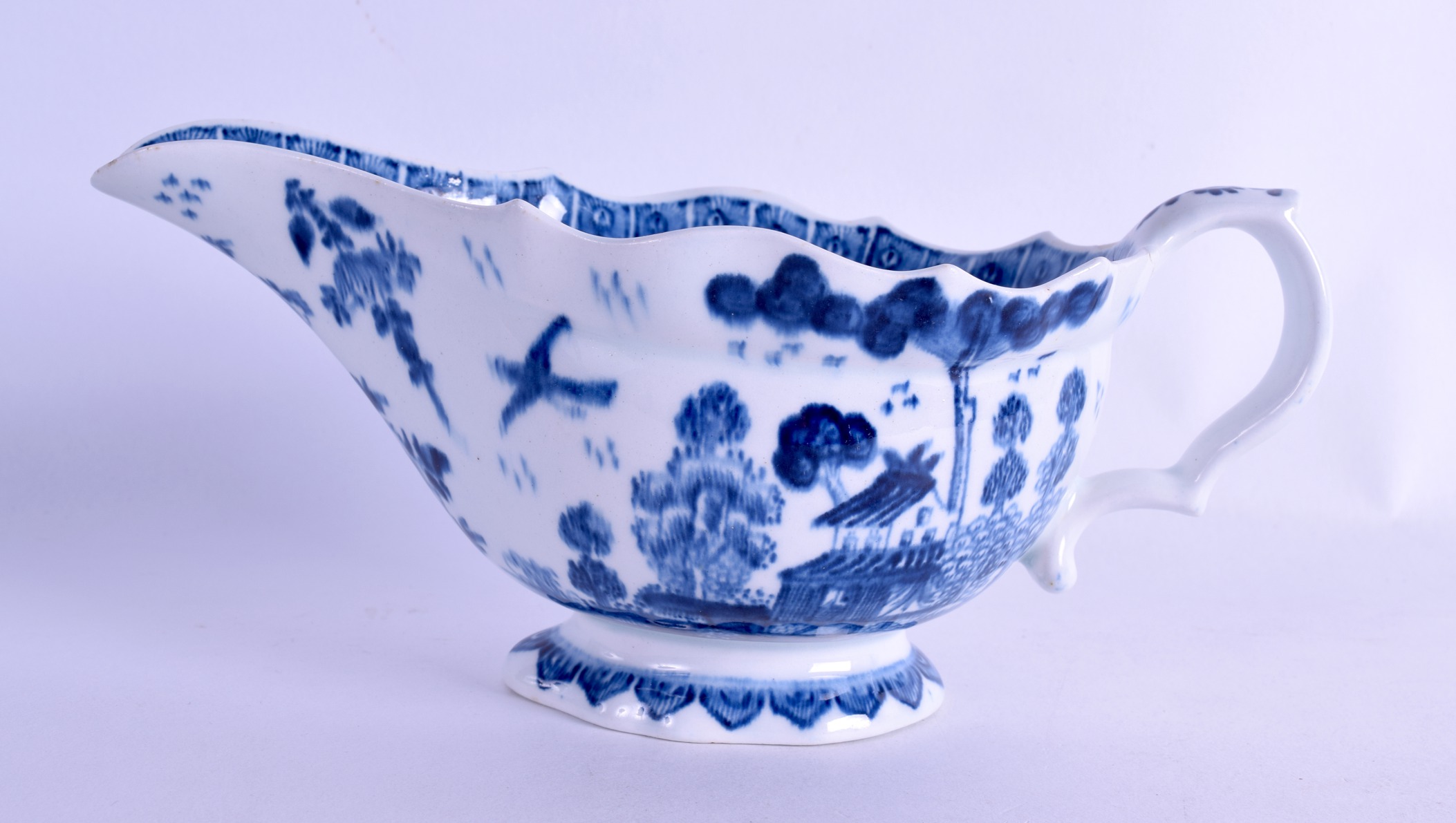 Bow sauceboat painted in blue underglaze with a house in a Chinese landscape. 20 cm wide.