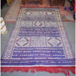 A GOOD BLUE GROUND RUG, decorated with symbols. 248 cm x 140 cm.