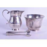 A STYLISH HAMMERED SILVER CREAM JUG AND SUGAR BASIN with associated dimpled sugar tongs. Chester &