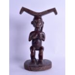 A GOOD AFRICAN TRIBAL CARVED WOODEN FIGURAL HEAD REST modelled with two opposing female holding