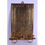 AN ARTS AND CRAFTS BRASS HANGING WALL PLAQUE with rotating twin sconces, decorated with foliage.