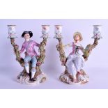 A PAIR OF 19TH CENTURY MEISSEN TWIN BRANCH CANDLEABRA modelled as seated figures holding onto