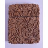 A 19TH CENTURY INDIAN CARVED SANDALWOOD CARD CASE decorated with swirling foliage. 8 cm x 10.25 cm.