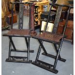 A PAIR OF EARLY 20TH CENTURY CHINESE WOODEN FOLDING CHAIRS, carved with foliage and precious