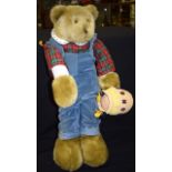 A LARGE STUFFED BEAR IN DUNGAREES, enjoying a pint of honey, smothered in bees. 64 cm high.