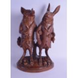 A RARE 19TH CENTURY BAVARIAN BLACK FOREST TOBACCO JAR modelled as a fox and hare wearing coats, upon