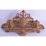 A LATE 19TH CENTURY FRENCH BRASS DESK STAND decorated with a central mask head and a foliate