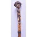 A RARE 19TH CENTURY CARVED BONE WALKING CANE the finial formed as a Japanese male holding a fan.