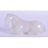 A CHINESE CARVED WHITE JADE FIGURE OF A HORSE modelled recumbent with incised features. 9 cm long.