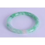 AN EARLY 20TH CENTURY CHINESE CARVED GREEN JADEITE CHILDS BANGLE. 6.25 cm diameter.