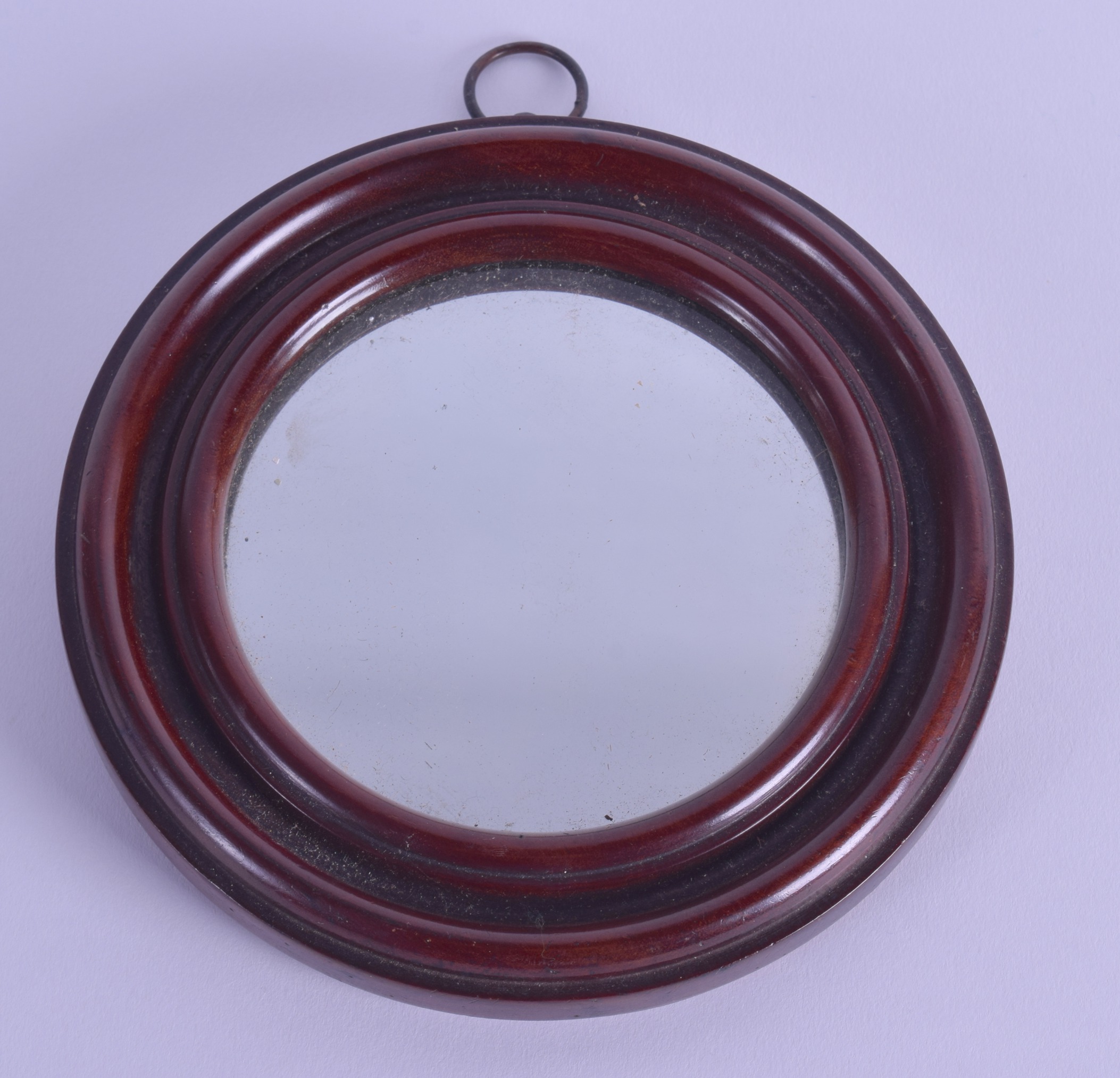 A GEORGE III MAHOGANY TRAVELLING MIRROR. 16 cm diameter.