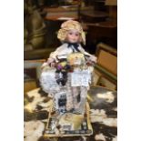 AN UNUSUAL EARLY 20TH CENTURY PORCELAIN DOLL, decorated extensively with sewing relation articles