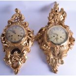 A MATCHED PAIR OF CARVED GILTWOOD CARTEL CLOCKS of scrolling classical form, overlaid with