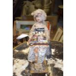 AN UNUSUAL EARLY 20TH CENTURY PORCELAIN DOLL, decorated extensively with sewing relation articles