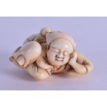 AN 18TH/19TH CENTURY JAPANESE EDO PERIOD CARVED IVORY NETSUKE modelled as a recumbent male with a