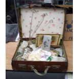 A VINTAGE SUITCASE containing various items. (qty)