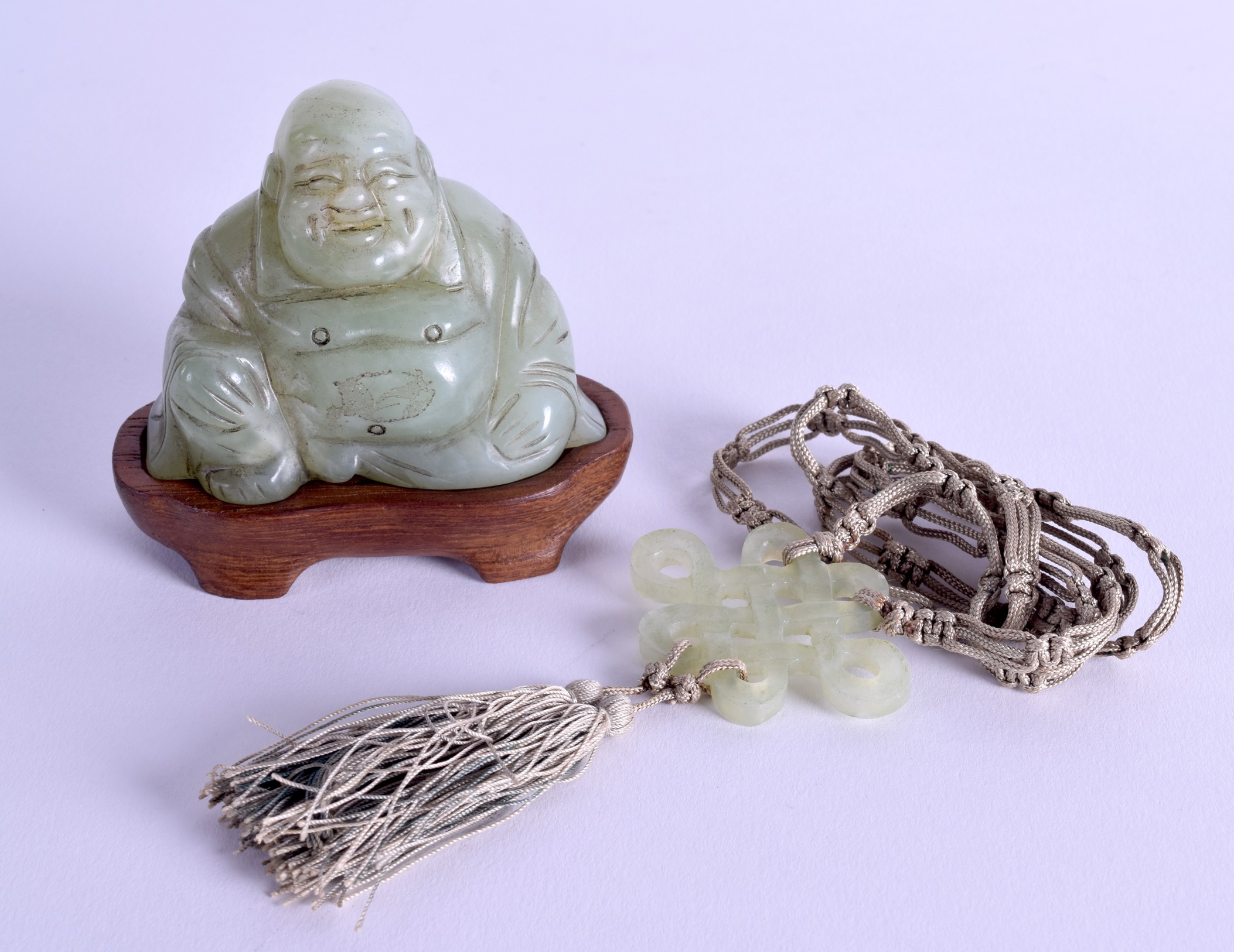 AN EARLY 20TH CENTURY CHINESE CARVED JADE FIGURE OF A BUDDHA together with a hardstone pendant. (2)