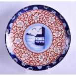 AN UNUSUAL 19TH CENTURY JAPANESE MEIJI PERIOD BLUE AND WHITE DISH with iron red foliate banding.