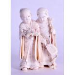 A 19TH CENTURY JAPANESE MEIJI PERIOD CARVED IVORY OKIMONO modelled as two males holding an open