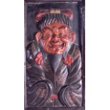 A 19TH CENTURY JAPANESE MEIJI PERIOD POLYCHROMED PLASTER PLAQUE modelled as a scowling male. 32 cm x