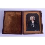 A MID 19TH CENTURY PAINTED IVORY PORTRAIT MINIATURE depicting a female wearing a black gown and