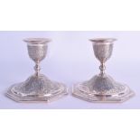 A PAIR OF LATE 19TH CENTURY INDO PERSIAN INDIAN WHITE METAL CANDLE STICKS decorated with foliage. 11