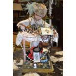 AN UNUSUAL EARLY 20TH CENTURY PORCELAIN DOLL, decorated extensively with sewing relation articles