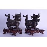 A PAIR OF SOUTH EAST ASIAN BRONZE BUDDHISTIC LIONS 20th Century, upon associated hardwood bases.