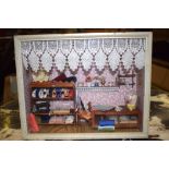 AN EARLY 20TH CENTURY DIORAMA, depicting collection of sewing related items in an interior. 22 cm