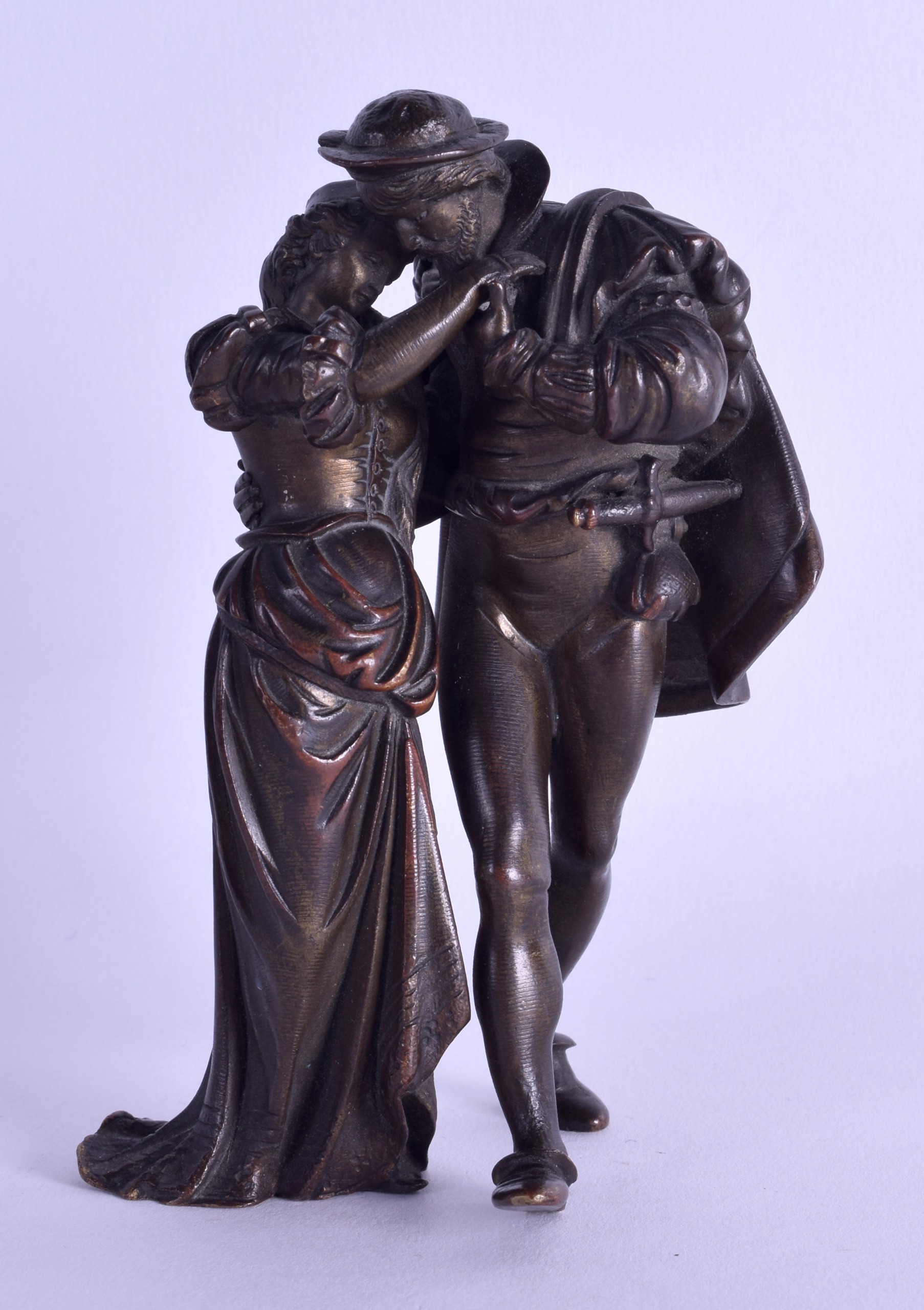 A LATE 19TH CENTURY EUROPEAN BRONZE FIGURE OF A CAVALIER modelled consoling a female. 12.75 cm