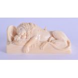 A FINE 19TH CENTURY EUROPEAN CARVED IVORY FIGURE OF A LION modelled fallen beside armour upon a