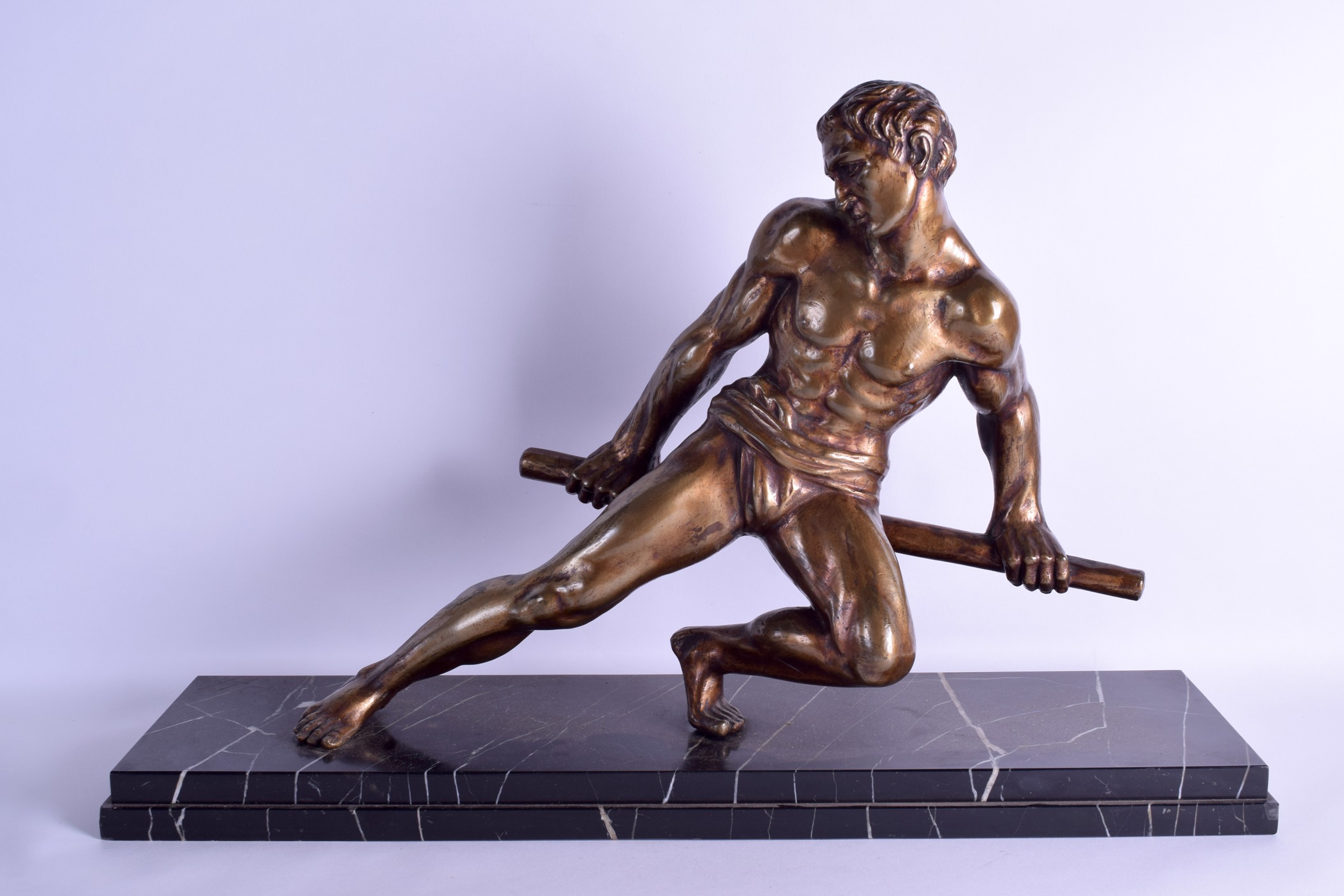 A LARGE ART DECO POLISHED BRONZE FIGURE OF A MUSCULAR MALE modelled upon a veined marble base. 66 cm