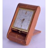 A 1950S CARTIER LEATHER BOUND BRASS TRAVELLING CLOCK with square form dial. 5 cm x 6.75 cm.