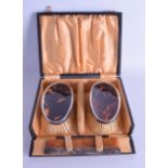 A CASED PAIR OF EARLY 20TH CENTURY SILVER AND TORTOISESHELL BRUSHES. Birmingham 1924.