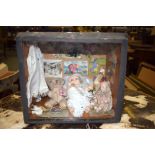 AN EARLY 20TH CENTURY DIORAMA, depicting two dolls and a bear in an interior. 24 cm x 27 cm.