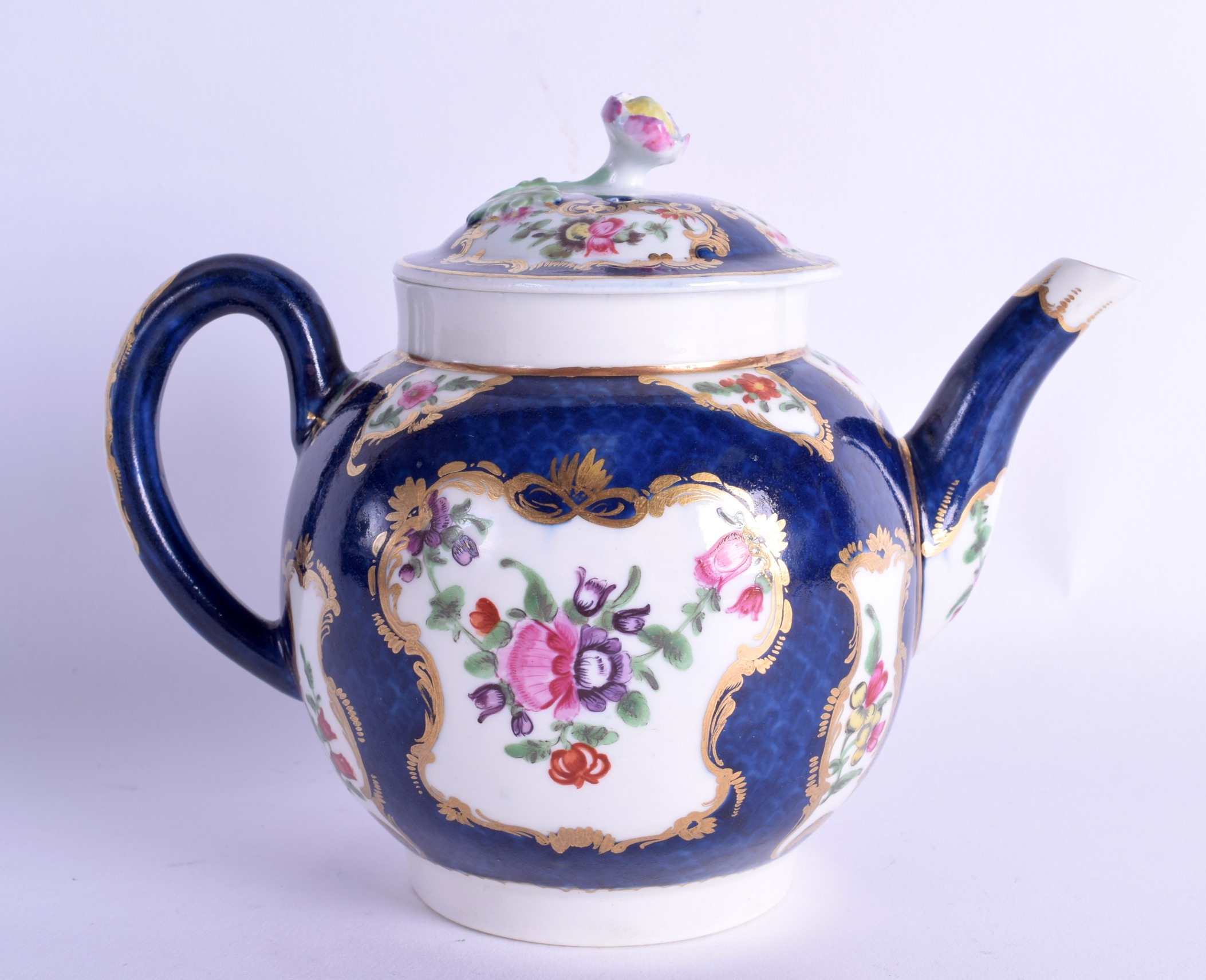 18th c. Worcester teapot and cover painted with English flowers on a blue scale ground, crescent