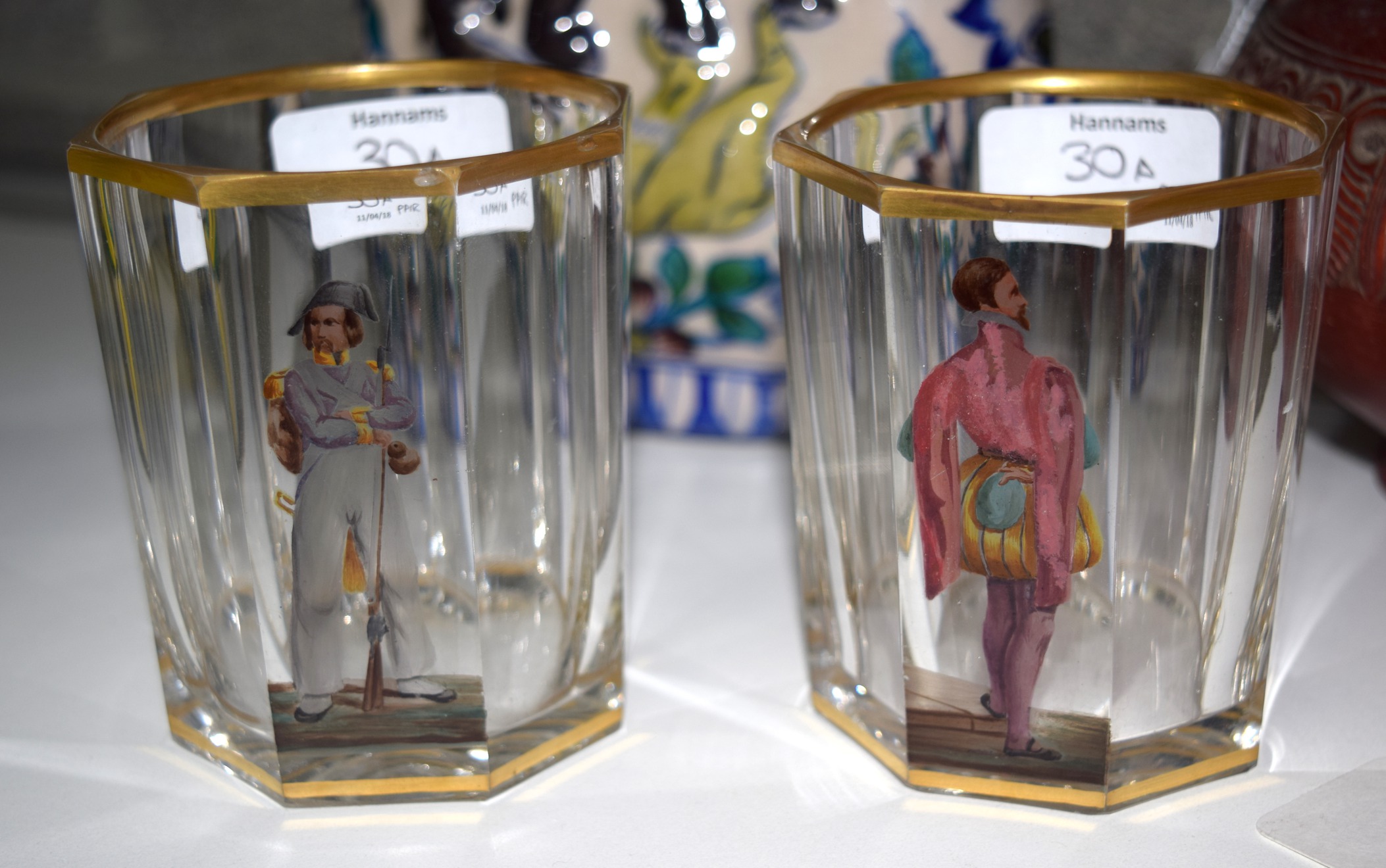 AN UNUSUAL PAIR OF EARLY 19TH CENTURY AUSTRIAN OCTAGONAL GLASSES painted with a male within a