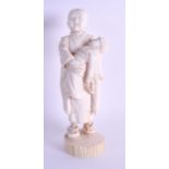 A 19TH CENTURY JAPANESE MEIJI PERIOD CARVED IVORY OKIMONO depicting a boy holding a child. 20 cm