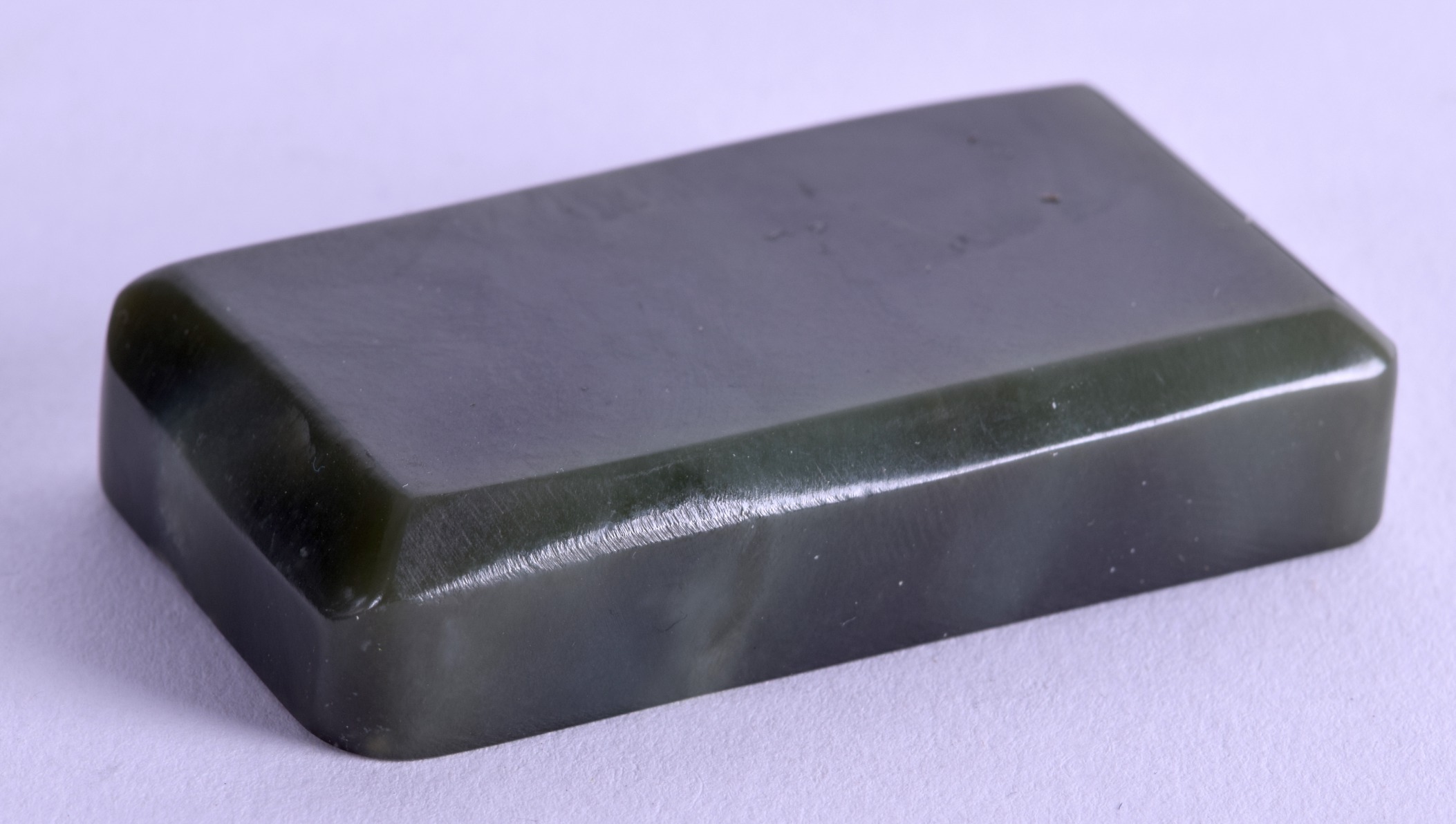 AN EARLY 20TH CENTURY CARVED JADE SCROLL WEIGHT of rectangular form. 6.5 cm wide.