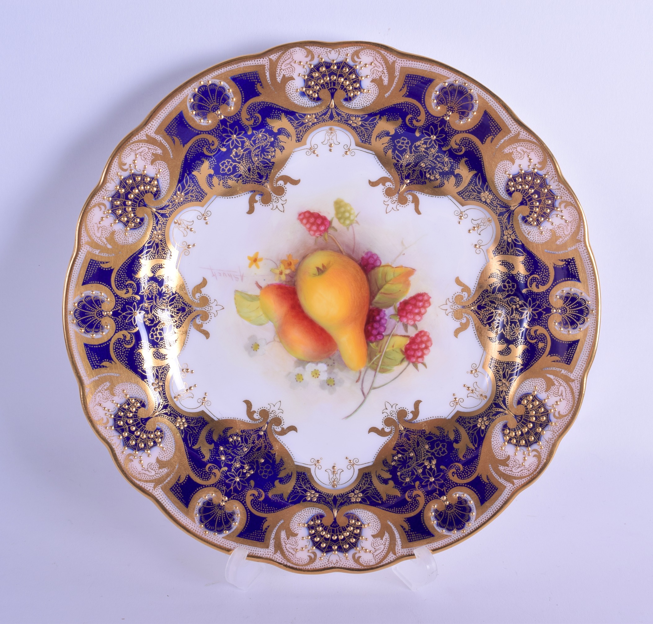 Royal Worcester plate painted with fruit under a blue and gilt border by Albert Shuck, signed date