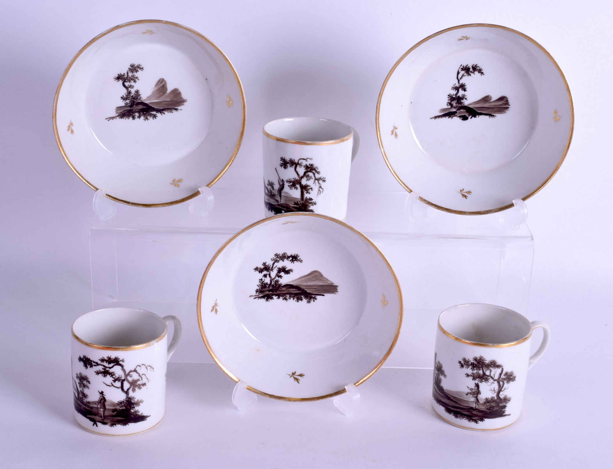 Early 19th c. set of three Paris porcelain coffee can and saucers en-grisaille with landscape and