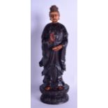AN EARLY 20TH CENTURY CHINESE CARVED IVORY AND HARDWOOD FIGURE OF GUANYIN modelled holding a