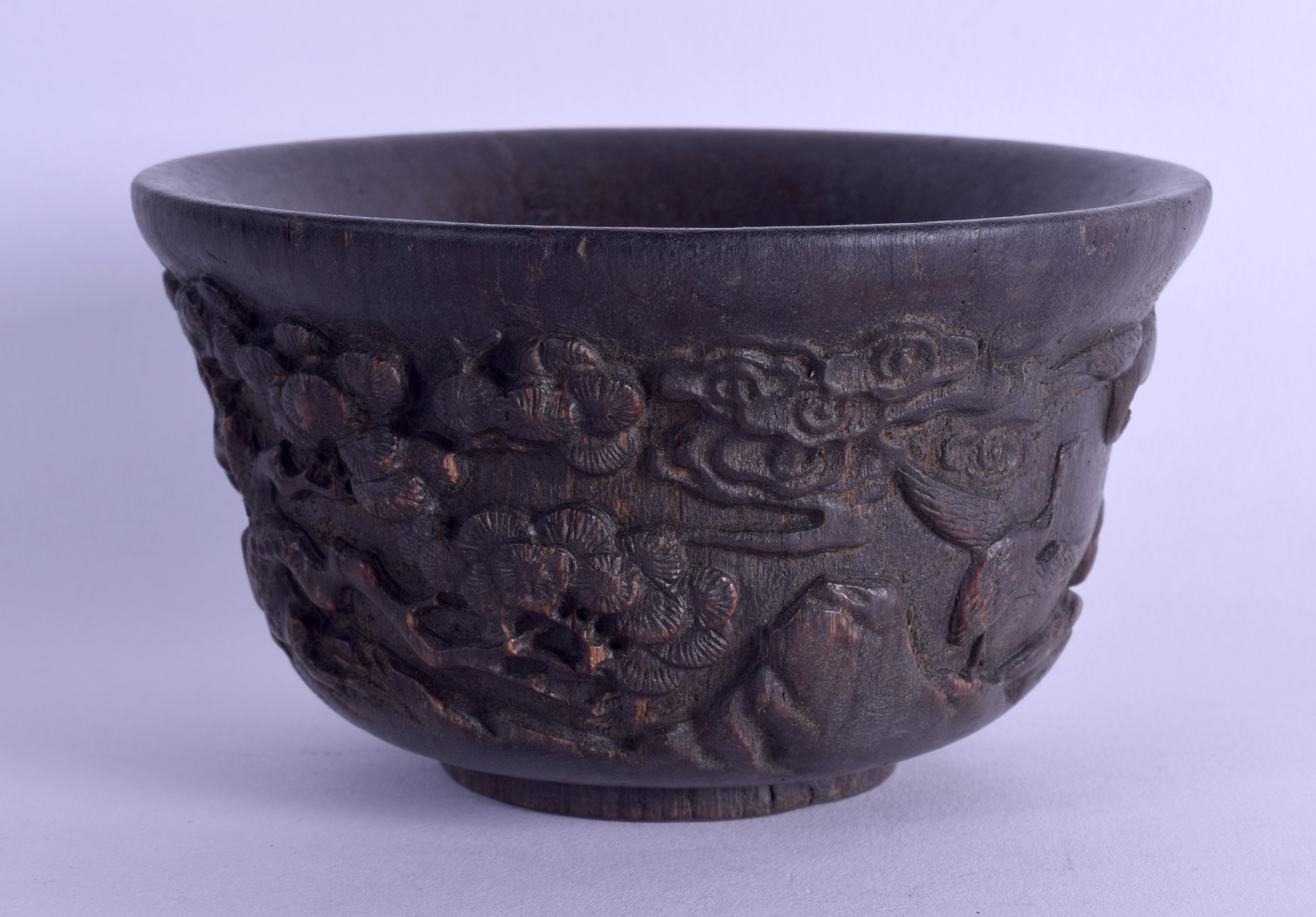 A CHINESE CARVED HARDWOOD CIRCULAR BOWL bearing Kangxi marks to base, decorated with flowering