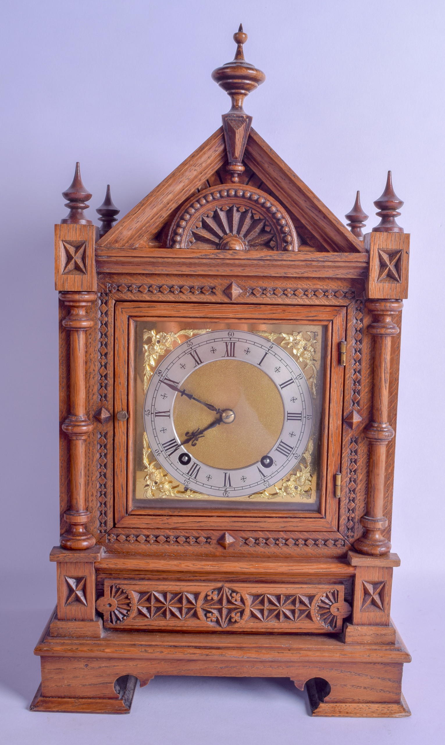 A LATE 19TH CENTURY GOTHIC REVIVAL CARVED OAK MANTEL CLOCK of architectural form, with brass mounted