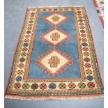 A BLUE GROUND RUG, decortaed with motifs. 158 cm x 106 cm.